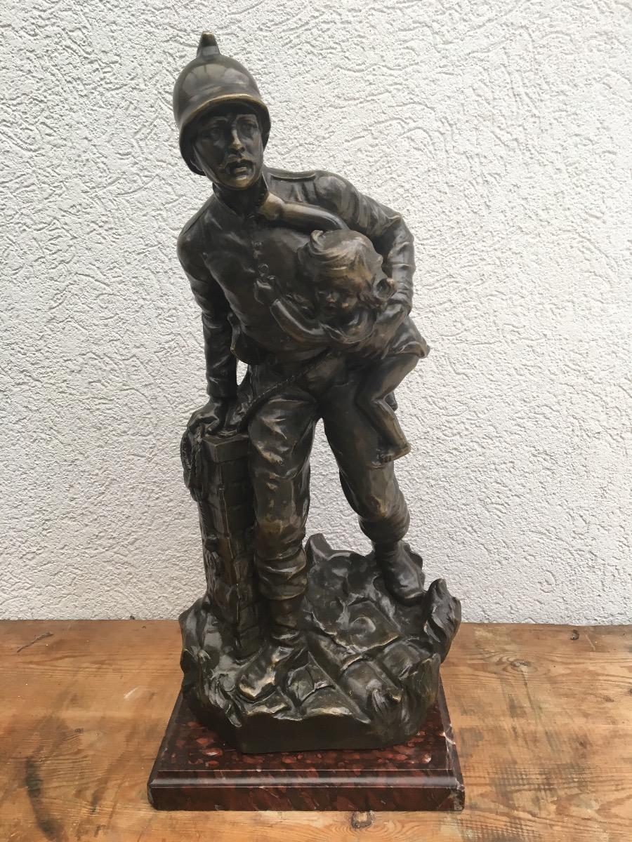 Bronzen beeld pompier met kind